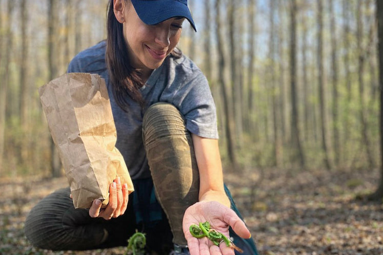 Foraging guide Jordan Madley, shown here with handfuls of fiddleheads, leads a workshop in May in which participants will gather wild greens and make a fresh pesto. 